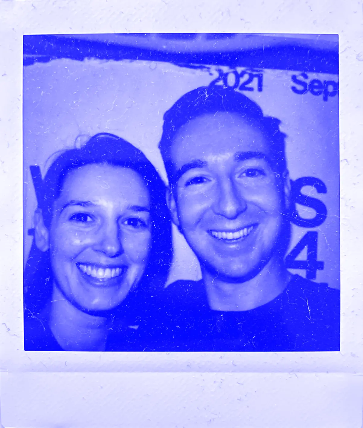 A polaroid of Jess and Patrick smiling.